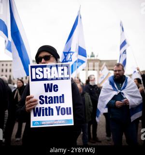 Israel Solidarity Demonstration Deu, Deutschland, Germania, Berlino, 06.10.2024 Demonstranten mit Schild Israel We Stand With You und Fahnen von Israel anlaesslich der Kundgebung und Demonstration von einem breiten Buendnis unter dem motto Gemeinsam Gegen Das Verbrechen der Hamas an Israel und Palaestinenser fuer fuer die Freilassung der Geisel und Geisel und das Enschass Herrsaft Hamas Israel und Herrsass Hamas Hamas Israel und Herrsassung und Herrass in Israel und Herrsfuer Herrsassung der Herrass. Jahrestag nach den toedlichen Terror von Hamas aus Gaza nach Israele 7. Oktober vor dem Brandenburger Tor a Berlin Deutsch Foto Stock