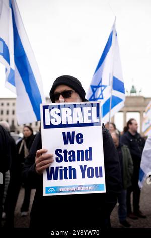 Israel Solidarity Demonstration Deu, Deutschland, Germania, Berlino, 06.10.2024 Demonstranten mit Schild Israel We Stand With You und Fahnen von Israel anlaesslich der Kundgebung und Demonstration von einem breiten Buendnis unter dem motto Gemeinsam Gegen Das Verbrechen der Hamas an Israel und Palaestinenser fuer fuer die Freilassung der Geisel und Geisel und das Enschass Herrsaft Hamas Israel und Herrsass Hamas Hamas Israel und Herrsassung und Herrass in Israel und Herrsfuer Herrsassung der Herrass. Jahrestag nach den toedlichen Terror von Hamas aus Gaza nach Israele 7. Oktober vor dem Brandenburger Tor a Berlin Deutsch Foto Stock