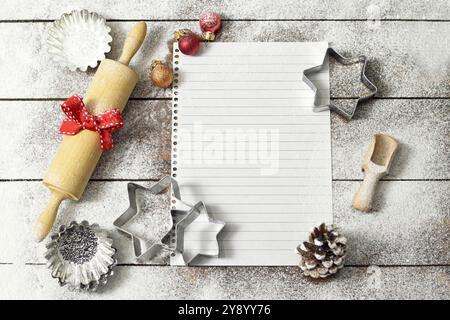 Sfondo da forno natalizio con spazio per le copie. Carta per ricette vuota e utensili di supporto. Foto Stock