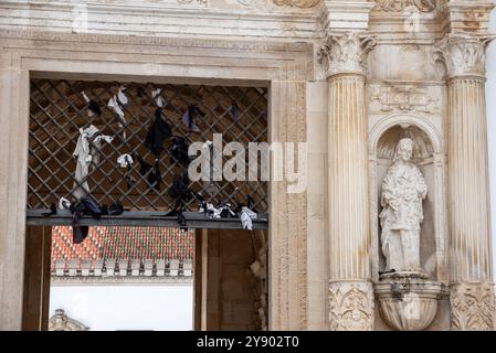 Abiti legati al cancello di ferro presso il vecchio edificio della famosa università di Coimbra, in Portogallo Foto Stock