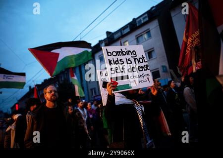 Essen, Germania. 7 ottobre 2024. Un segnale che recita: "Bombardare bambini non è autodifesa” è visto in un raduno pro-palestinese sotto lo slogan "contro la ripetuta aggressione di Israele” in occasione dell'anniversario dell'attacco di Hamas a Israele. Crediti: Fabian Strauch/dpa/Alamy Live News Foto Stock