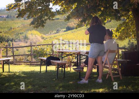 Un paio di persone vogliono pranzare guardando la raccolta delle uve tge in piemonte. Foto Stock