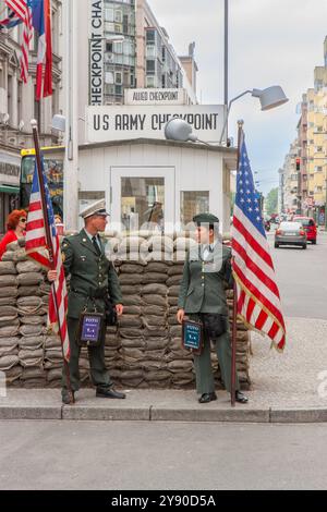 Berlino, Germania 30 maggio 2009. Checkpoint Charlie Berlin. Due soldati americani, uomo e donna, con una bandiera americana in mano. Foto Stock