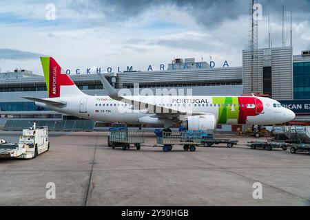 TOCCARE Transportes Aéreos Portugueses Airbus A320 all'aeroporto Arlanda di Stoccolma all'uscita, Terminal 5 dell'aeroporto sullo sfondo. Foto Stock