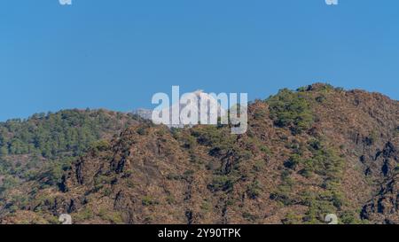 La vetta del monte Tahtali Olympos, vista dalla via Licia a Cirali, Antalya, Turchia. Il paesaggio panoramico presenta foreste lussureggianti, cieli blu e rugg Foto Stock