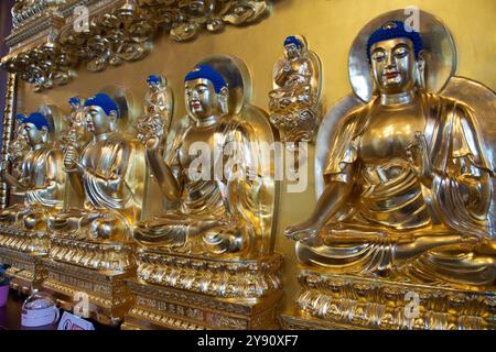 Peterborough, Ontario, Canada / 05-18-2024: Le luccicanti statue dorate del Buddha all'interno del tempio buddista. Foto Stock