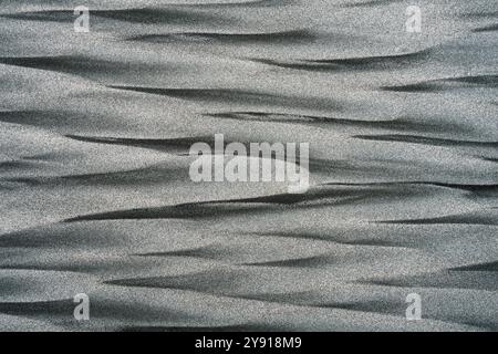 Background: La risorsa grafica artistica della natura. Una scena monocromatica di sabbia nera vulcanica e dorata mescolata a forme di diamante vicino al mare, il piccolo Wanganui Foto Stock