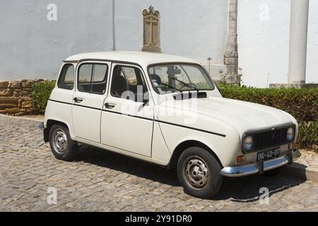 Auto d'epoca bianca su ciottoli di fronte a un edificio storico, Renault 4, R4, Tavira, Faro, Algarve, Portogallo, Europa Foto Stock