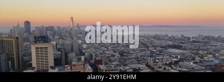 Riflessi aranciati sembrano rimbalzare il più alto edificio come notte arriva all'area della Baia di San Francisco Foto Stock