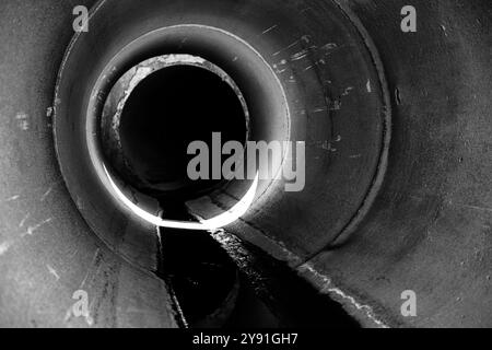 All'interno di un canale di drenaggio circolare in calcestruzzo con un triclo d'acqua Foto Stock