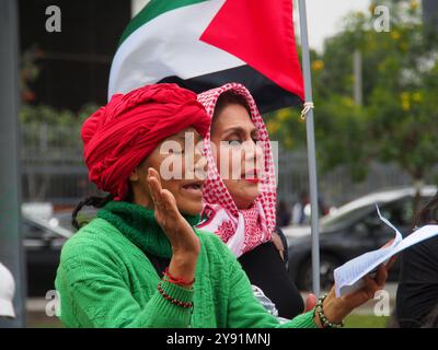 Lima, Perù. 7 ottobre 2024. Donne in hijab che trasportano bandiere palestinesi quando decine di manifestanti sono scese in piazza a Lima in solidarietà con la Palestina e il Libano per celebrare il primo anniversario della guerra tra Israele e Hamas, iniziata il 7 ottobre 2023, quando Hamas uccise e rapì israeliani al festival musicale Nova. Credito: Fotoholica Press Agency/Alamy Live News Foto Stock