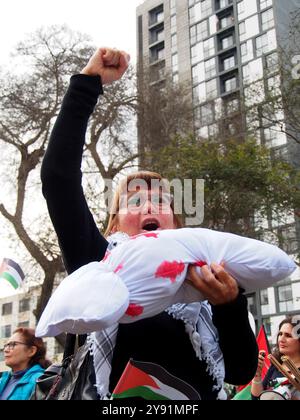 Lima, Perù. 7 ottobre 2024. Donna che porta una bambola che simula un bambino morto quando decine di manifestanti sono scesi in piazza a Lima in solidarietà con la Palestina e il Libano per celebrare il primo anniversario della guerra tra Israele e Hamas, iniziata il 7 ottobre 2023, quando Hamas uccise e rapì israeliani al festival musicale Nova. Credito: Fotoholica Press Agency/Alamy Live News Foto Stock