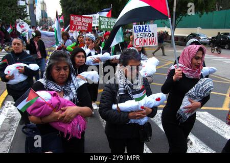 Lima, Perù. 7 ottobre 2024. Donna che indossa un hijab che trasporta una bambola che simula un bambino morto quando decine di manifestanti sono scesi in piazza a Lima in solidarietà con la Palestina e il Libano per celebrare il primo anniversario della guerra tra Israele e Hamas, iniziata il 7 ottobre 2023, quando Hamas ha ucciso e rapito israeliani al festival musicale Nova. Credito: Fotoholica Press Agency/Alamy Live News Foto Stock