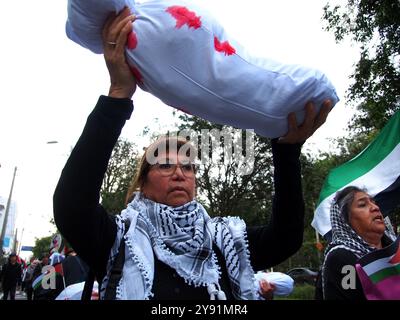 Lima, Perù. 7 ottobre 2024. Donna che indossa un hijab che trasporta una bambola che simula un bambino morto quando decine di manifestanti sono scesi in piazza a Lima in solidarietà con la Palestina e il Libano per celebrare il primo anniversario della guerra tra Israele e Hamas, iniziata il 7 ottobre 2023, quando Hamas ha ucciso e rapito israeliani al festival musicale Nova. Credito: Fotoholica Press Agency/Alamy Live News Foto Stock