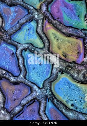 Close up photography of oil in melting snow tire tracks of an ATV. Foto Stock