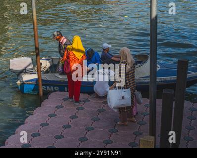 Balikpapan, Indonesia - 26 giugno 2024. I passeggeri saliranno a bordo del motoscafo con i loro effetti personali fino a destinazione. Foto Stock