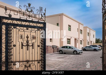 Case Villa con auto parcheggiate all'aperto in Medio Oriente. Esterno di una casa a due piani dal design moderno e parcheggio in un cortile. Case abitative ap Foto Stock