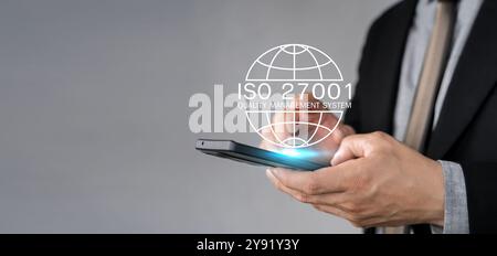 Uomo d'affari in possesso di un tablet e con un simbolo ISO 2700, sistema di gestione dello standard di sicurezza delle informazioni, certificazione ISO 27001 informazioni di sicurezza Foto Stock