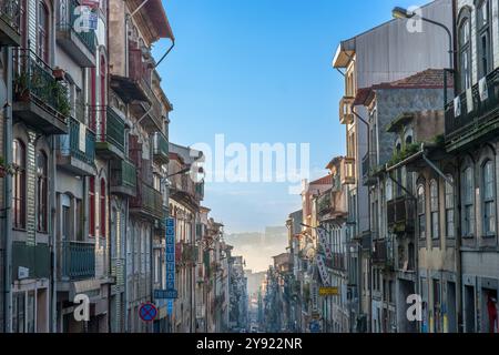 Porto, Portogallo 29 gennaio 2011. Una vista in lontananza in una strada di Porto che scende in collina alla luce del mattino e nebbia in lontananza. Foto Stock