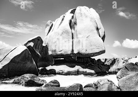 massa monumentale di granito eroso dal mare e dal vento sorge per proteggere una piccola insenatura di mare oceanico trasparente Foto Stock