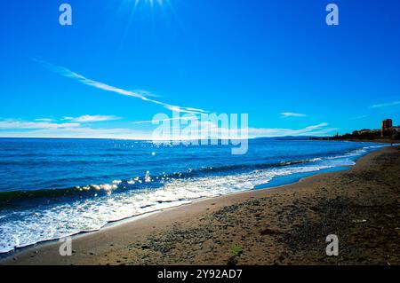 il sole brilla sul mare a Puerto Banus in Andalusia, Spagna con la colonna d'Ercole sullo sfondo Foto Stock