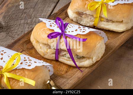 Deliziosi mini panini avvolti da elegante carta in pizzo e nastri colorati, perfetti per feste ed eventi Foto Stock