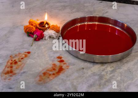 Una lampada di fango in fiamme (diya) circondata da fiori vibranti durante Navratri, un festival indù che celebra le dee indiane. Catturato a Uttarakhand, India. Foto Stock