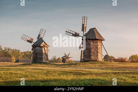 Tre mulini a vento nel Museo di architettura popolare e Folkways dell'Ucraina a Pyrohiv. Tradizionali mulini a vento in legno al tramonto. Foto Stock