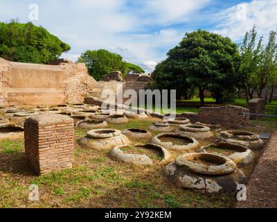 Caseggiato dei doli (Casa della Dolia) (117- 138 d.C.) - area di stoccaggio di un complesso commerciale per grandi liquidi (olio, vino) che erano in parte incastonati nel terreno (dolia defossa) - Parco Archeologico di Ostia Antica, Roma, Italia Foto Stock