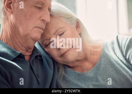 Riposate, rilassatevi e le coppie anziane si abbracciano in casa, in soggiorno e si legano o dormono insieme con il supporto sul divano. Pensionamento, vacanze e anziano con Foto Stock