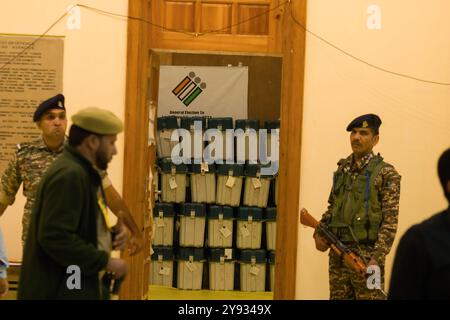 I soldati paramilitari indiani sono in guardia fuori da una stanza forte dove le macchine elettorali elettroniche (EVM) sono tenute mentre i funzionari elettorali contano i voti in un centro di conteggio elettorale a Srinagar. Con la sicurezza multilivello in atto, inizia il conto alla rovescia per i risultati delle elezioni dell'assemblea del Jammu e del Kashmir del 2024. Il territorio dell'Unione è destinato ad avere un governo eletto dal giugno 2018, quando il Partito Bharatiya Janata (BJP) ruppe la sua alleanza con il Partito Democratico Popolare (PDP), costringendo Mehbooba Mufti a dimettersi da primo ministro. Otto mesi dopo, il 5 agosto 2019, il primo ministro indiano Narend Foto Stock