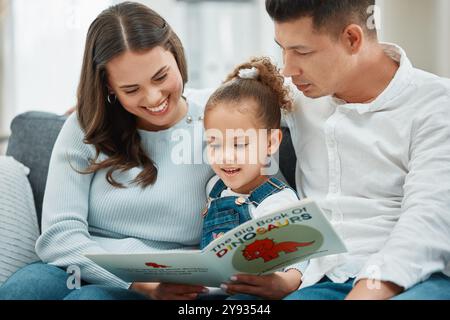 Famiglia felice, figlia e lettura con un libro sul divano per imparare, studiare o raccontare insieme a casa. Madre, padre e figlio o figlio con Foto Stock