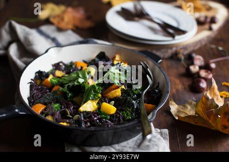 Vibrazioni autunnali rustiche con tagliatelle di riso nero, zucca e cavolo, che mostrano la taglia della stagione con toni terrosi. Foto Stock