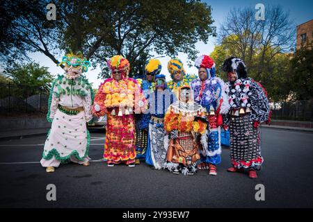 Una foto di gruppo di 6 uomini e un bambino di 7 anni, il tutto in costumi elaborati. Prima della Parata Dominicana. A Jackson Heights, Queens, New York, 2024. Foto Stock