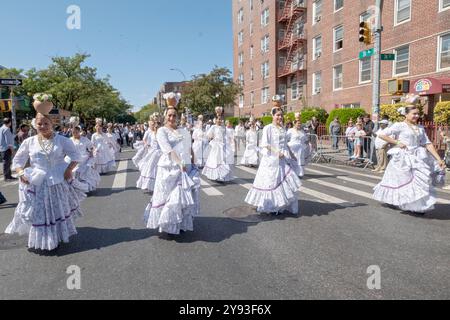 Un gruppo eterogeneo di donne paraguaiane danzano e marciano in costumi bianchi. Alla Queens Hispanic Day Parade del 2024 a Jackson Heights. Foto Stock