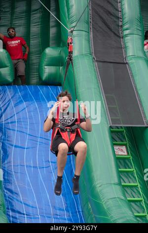 NIENTE MANI sotto un occhio vigile, il ragazzo cavalca la zip Line Amazon a mani libere durante la festa del Putnam Valley Town Day del 2024 nella contea di Putnam, New York. Foto Stock