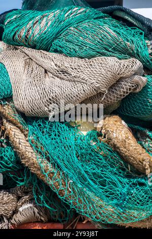 Immagine astratta di un mucchio di vecchie reti da pesca impilate una sopra l'altra sulla banchina di un porto o di un porto greco Foto Stock