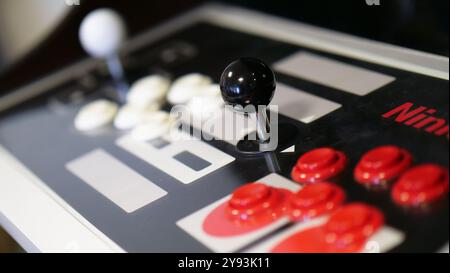 Primo piano di un classico joystick arcade e dei pulsanti su una console di gioco, che catturano l'essenza del gioco rétro e della nostalgia Foto Stock