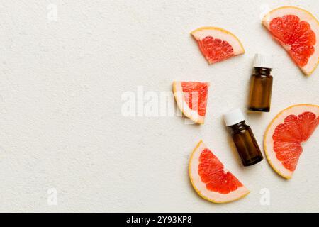 Bottiglie con olio essenziale di pompelmo su sfondo in legno. Medicina alternativa vista dall'alto con spazio copia. Foto Stock