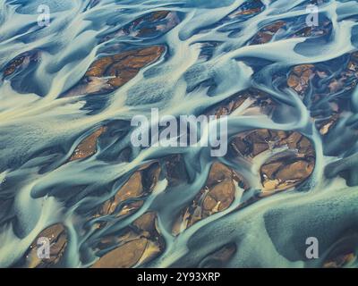 Vista aerea astratta effettuata da un drone del fiume strutturato lungo la costa meridionale islandese, Islanda, regioni polari Foto Stock