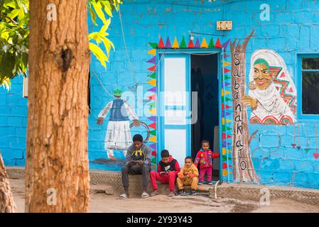 Bambini di fronte alla facciata decorata della loro casa, villaggio nubiano sull'isola Elefantina sul Nilo, Assuan, Egitto, Nord Africa, Africa Foto Stock