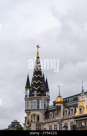 Una vista dettagliata dell'edificio della Old National Bank of Georgia a Batumi, che mostra la sua guglia in stile gotico, la cupola dorata e la facciata ornata Di Una storica a Foto Stock