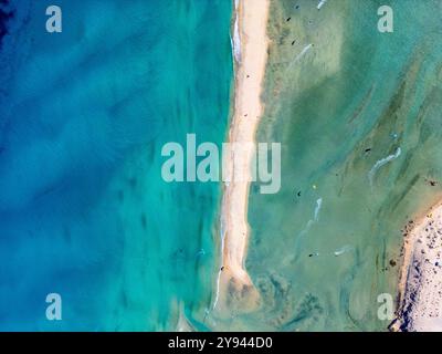 La vista dei droni mostra i toni blu e verde dell'oceano sulla spiaggia di Sotavento a Fuerteventura, illustrando la combinazione dinamica di coste sabbiose a. Foto Stock