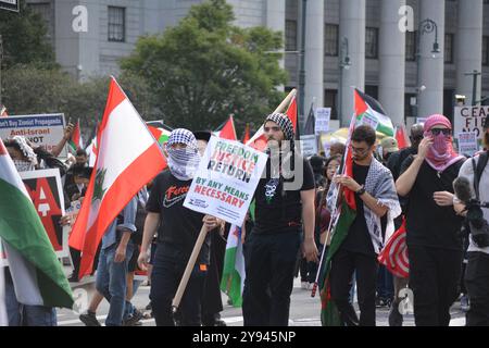 Persone con cartelli e bandiere durante una manifestazione pro Palestina nel primo anniversario degli attentati del 7 ottobre in Israele a New York. Foto Stock