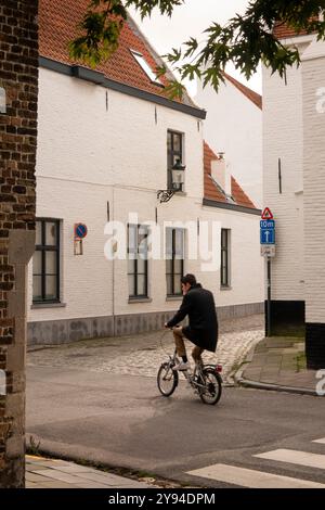 Belgio, Fiandre, Bruges, Jakobinessenstraat ciclista in una strada vuota Foto Stock