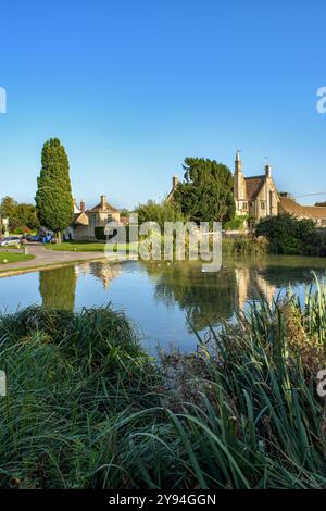 Il pittoresco villaggio di Biddestone e lo stagno delle anatre nelle Cotswolds, in Inghilterra, in estate dove è stata girata Agatha Raisin Foto Stock