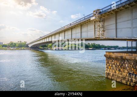 Branko Bridge collega le rive del fiume Sava a Belgrado, mostrando il suo design moderno su uno sfondo di nuvole e luce solare che si riflette sull'acqua. Foto Stock