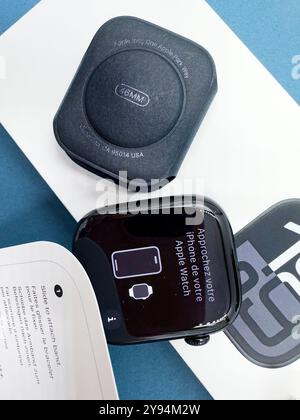 Confezione con la nuova configurazione dello smartwatch Apple Watch serie 10 del 2024, unboxing e braccialetto intercambiabile su sfondo blu Design elegante Foto Stock