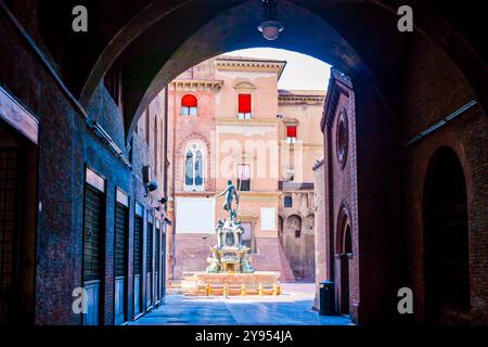 La vista sulla Fontana del Nettuno attraverso il passo ad arco di Palazzo Re Enzo, Bologna, Italia Foto Stock