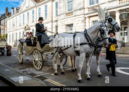 Un tradizionale pullman e cavalli parcheggiati nella High Street pubblicizza la grande riapertura dello storico White Hart Hotel, High Street, Lewes, Sussex, Regno Unito. Foto Stock